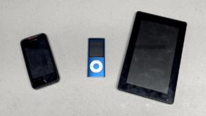 From left to right: HTC Droid Incredible, a blue 4th generation iPod Nano, and a NextBook Android tablet.